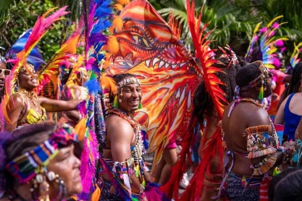 Carnival reveler in vibrant feathered headdress and beaded costume at Carnival in Bermuda