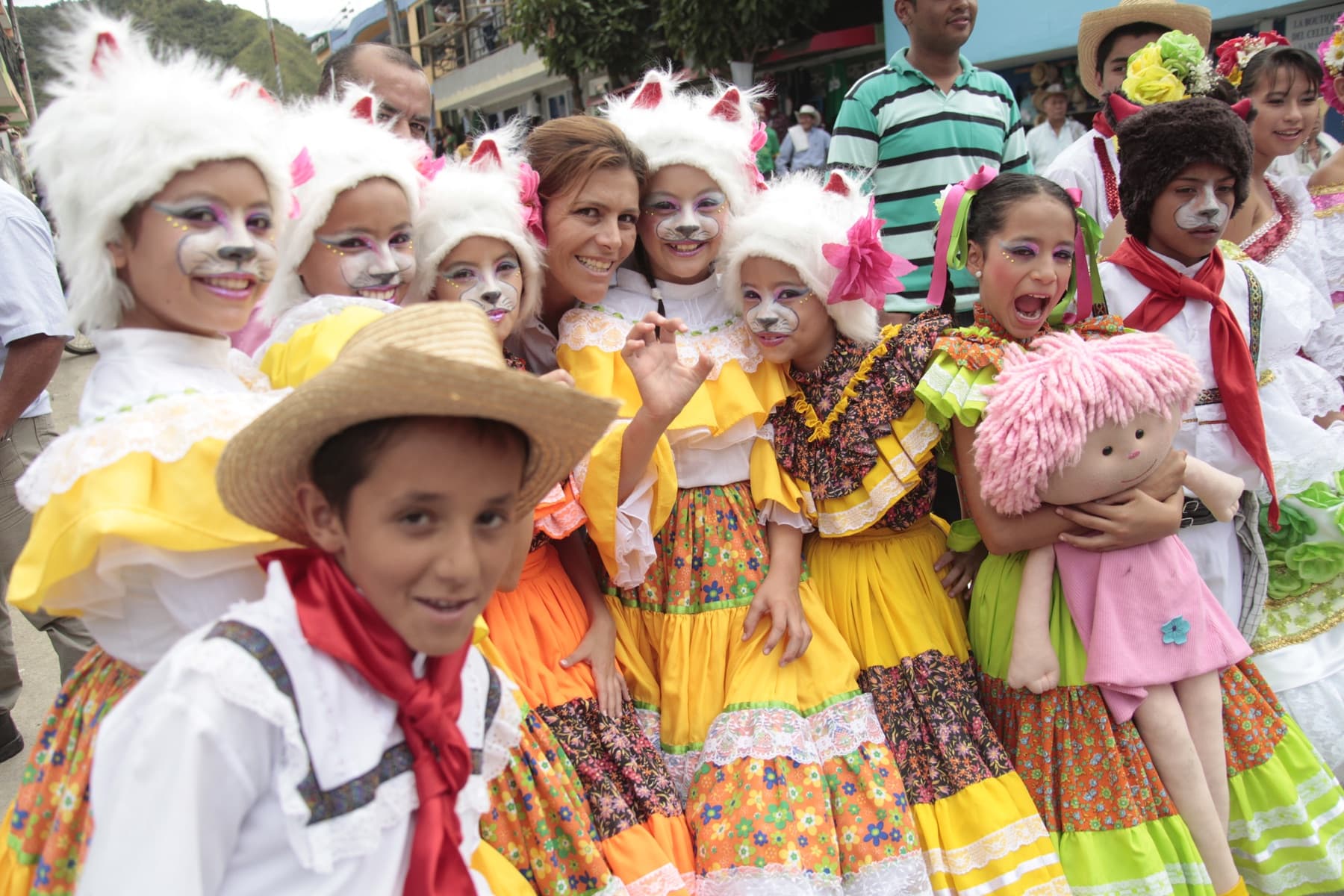 Children in traditional Colombian folk costumes with floral dresses and cat headpieces at the Festival del Bambuco in Neiva