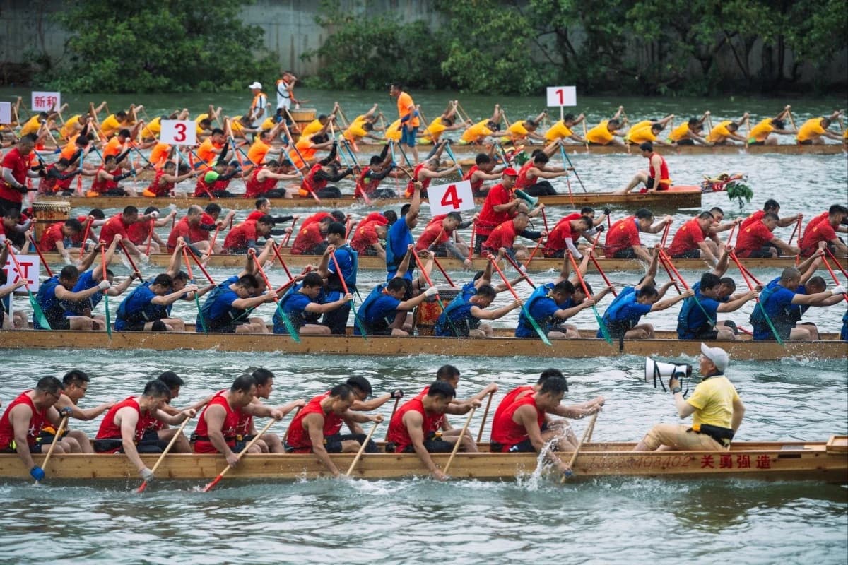 Synchronized dragon boat teams racing in Hong Kong, with twenty paddlers per vessel paddling to drum beats