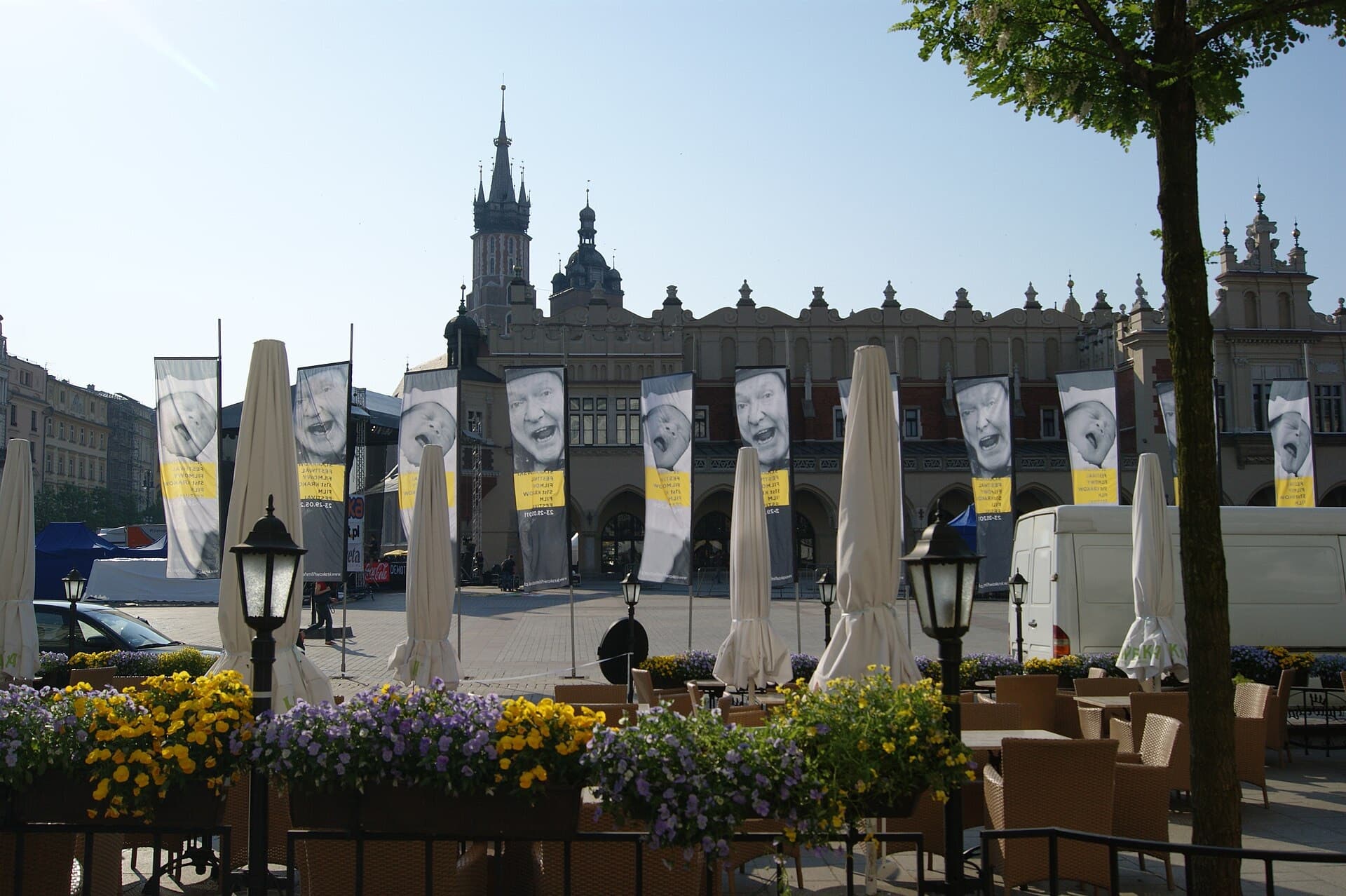 Festival banners with portraits hanging across Krakow's Main Market Square in front of historic architecture
